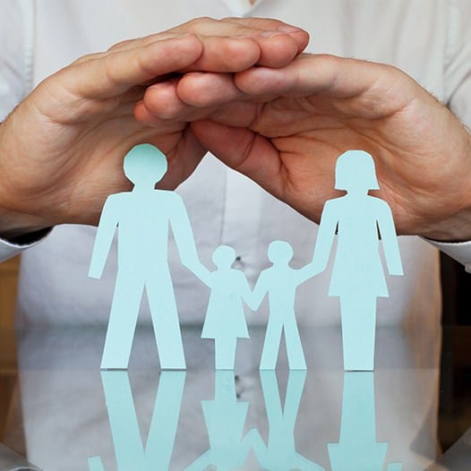 Hands holding paper cutout of family of four