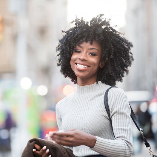 Woman smiling with a cityscape in the background