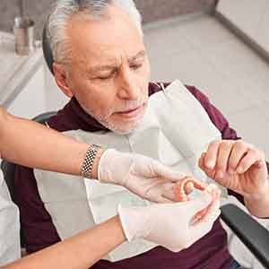 A dental patient examining the materials of a denture