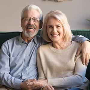 A cheerful elderly couple sitting on a couch