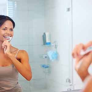 Woman smiling while brushing teeth